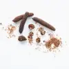 Dried whole and crushed Javanese long pepper (Piper longum) on a white background, a raw material for high-piperine herbal extracts from an Indonesian B2B supplier.